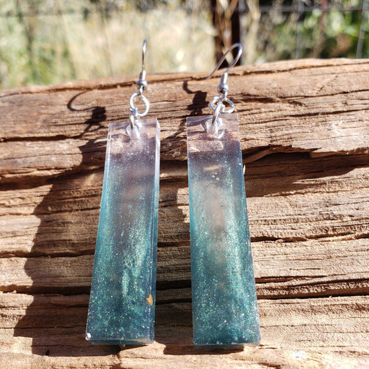 Teal rectangular boho dangle earrings on a wooden surface with a natural background